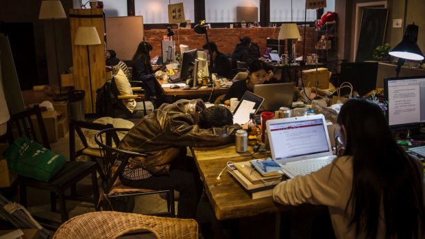 Employees of start ups work at their desks at You+ in Beijing.