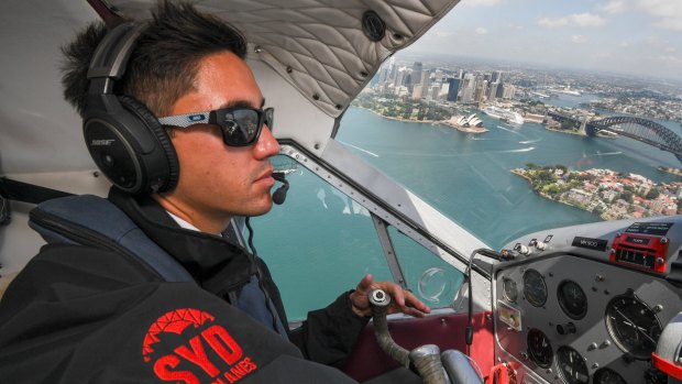 Pilot Daniel Johnson flies over Sydney Harbour. 