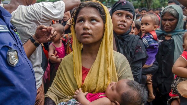 Rohingya Muslim women, who crossed over from Myanmar into Bangladesh, wait to receive aid near Balukhali refugee camp.