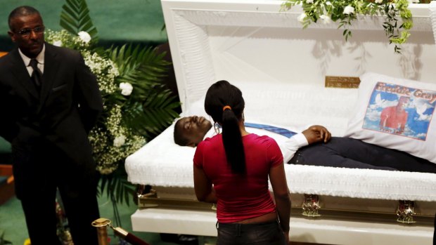 A mourner stands in front of the open casket of 25-year old Freddie Gray.