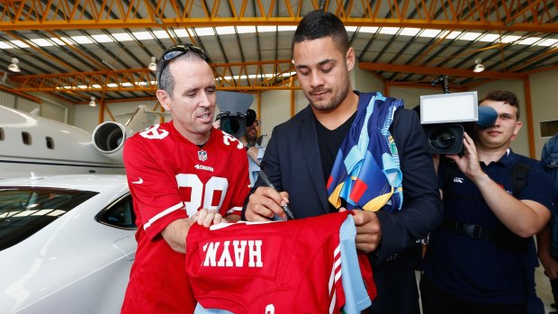 Man of many codes: Jarryd Hayne signs autographs for fans during a press conference at Gold Coast Airport on Wednesday.