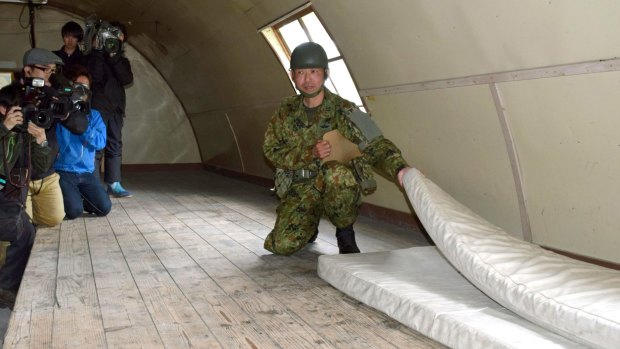 A member of the Self-Defence Forces shows the mattress which the 7-year-old boy was using inside a building in a military drill area in Shikabe town.