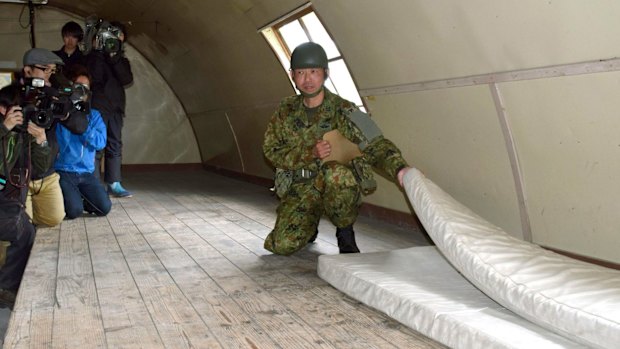 A member of the Self-Defence Forces shows the mattress which the 7-year-old boy was using inside a building in a military drill area in Shikabe town.