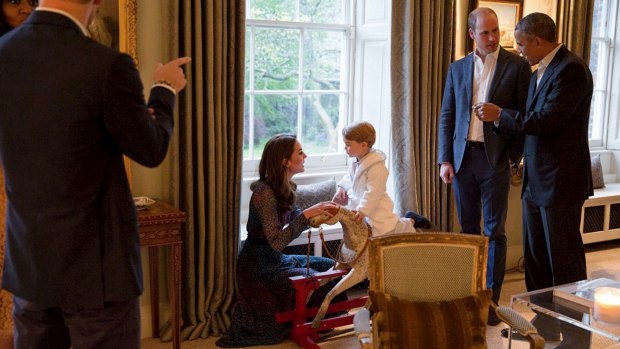 Prince George plays on the rocking horse previously given by the Obamas.