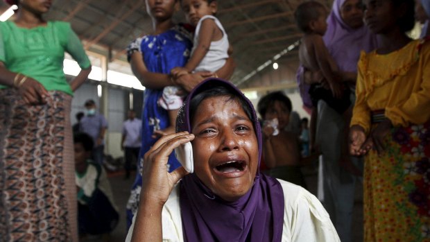 A Rohingya migrant who arrived in Indonesia by boat cries while speaking on a mobile phone with a relative in Malaysia.