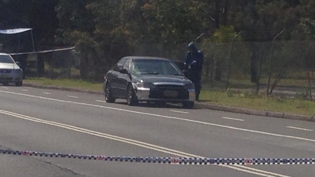 Evidence: Police are examining the car abandoned on East Street, Lidcombe.