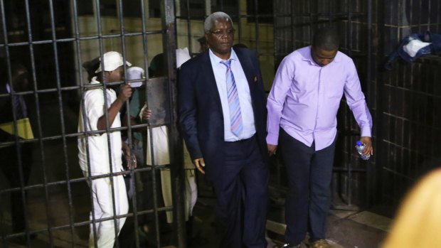 Zimbabwe's former finance minister, Ignatius Chombo, centre and Kudzanai Chipanga are led to a prison truck at the magistrates courts in Harare.