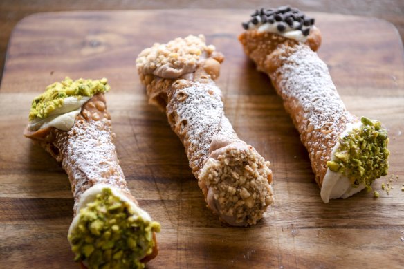 From left: Pistachio, Nutella and classic cannoli piped with ricotta-based fillings and dipped in crushed nuts and/or chocolate chips.