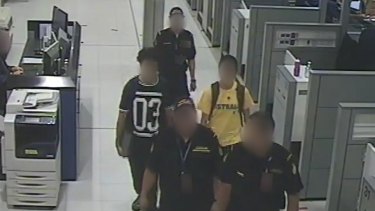 The teens are escorted at Sydney Airport by Customs officials.
