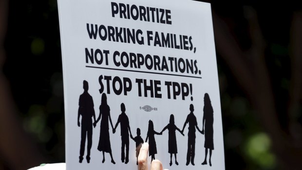 A demonstrator holds up a sign as nurses rally outside the offices of Senator Dianne Feinstein's office  in San Diego, California, to urge her to vote against the fast-track authority of the Trans-Pacific Partnership.