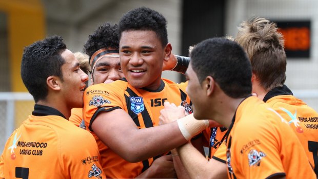 Huge talent: Mosese Suli is mobbed by his Tigers teammates after scoring a try in a junior match in 2015.