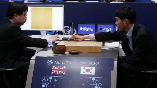 South Korean professional Go player Lee Sedol, right, puts the first stone against Google's artificial intelligence program, AlphaGo, during the Google DeepMind Challenge Match in Seoul.