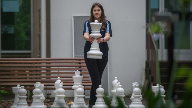 One of ACT's top girl chess players, Saffron Archer, holds the white queen.