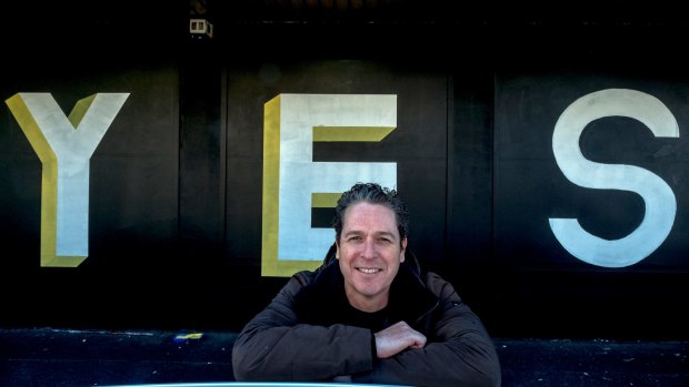 The Night Cat owner Justin Stanford with the 'yes' mural outside the Fitzroy club.