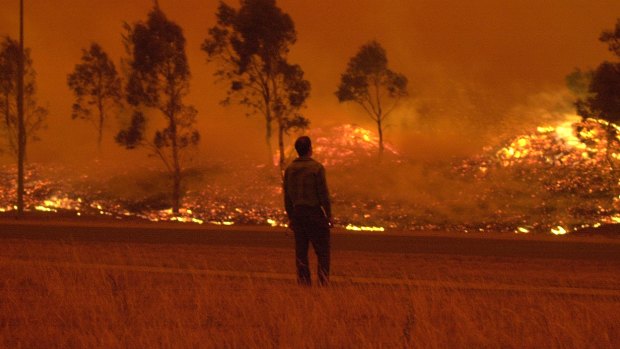 A resident watches grassland burn in Gordon on Saturday, January 18, 2003.