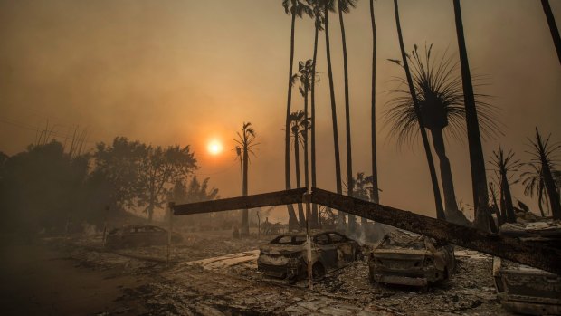 Smoke rises behind a leveled apartment complex as a wildfire burns in Ventura, California.