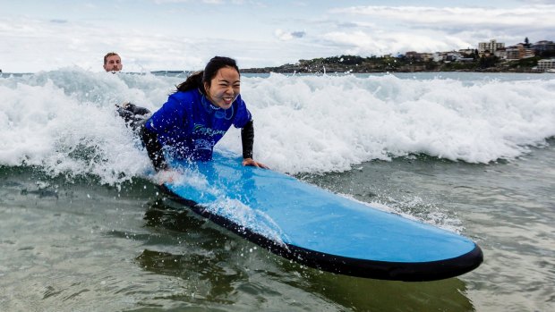 Xiaodan Zhang gets a surfing lesson in Bondi as part of a push to attract more middle class Chinese tourists.