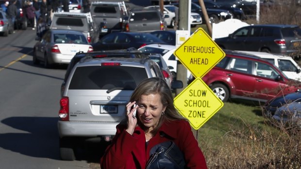 A woman mourns while speaking on the phone near Sandy Hook Elementary School, after the December 2012 shooting there which left 20 children and six school staff dead.