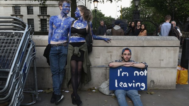 A young couple painted as EU flags protest on outside Downing Street against the United Kingdom's decision to leave the EU. 