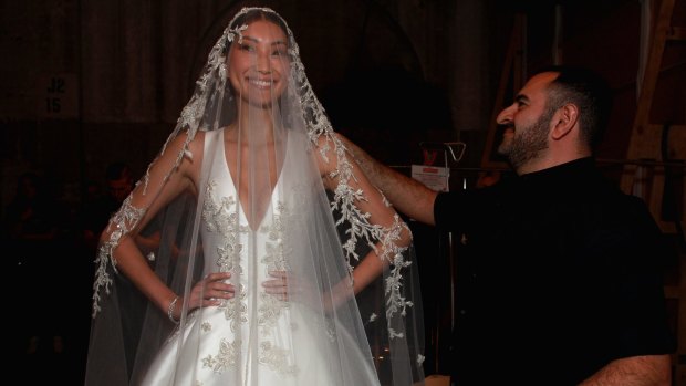 Designer Steven Khalil helps his bridal model backstage before his Fashion Week debut.