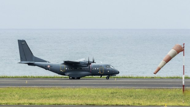 A French military transport plane taxis on the runway at the airport in Saint-Denis at the start of a search mission.