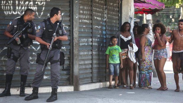 Military Police officers look over their shoulders during an ongoing police operation in Rio de Janeiro.