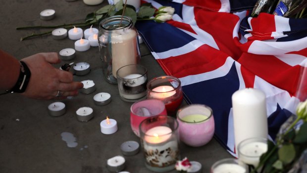 Flowers and candles are seen after a vigil in Albert Square, Manchester, England.