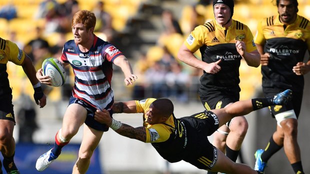 Nic Stirzaker is tackled by the Hurricanes' TJ Perenara.