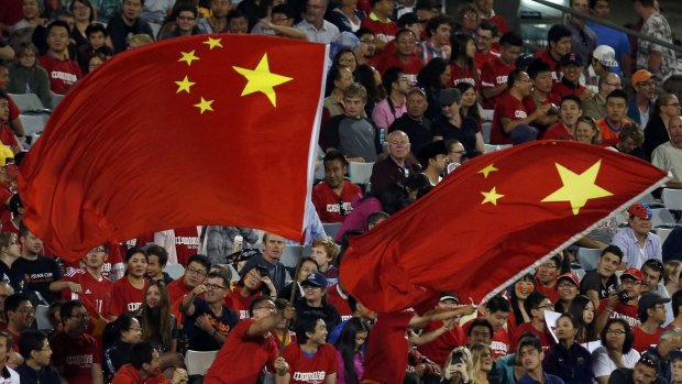China's fans wave giant national flags during their Asian Cup Group B soccer match against North Korea in Canberra on January 18, 2015.