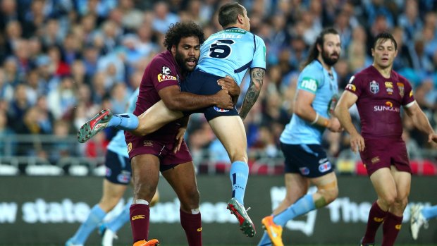 Mitchell Pearce of the Blues is tackled in the air by Sam Thaiday of the Maroons during game one of the State of Origin.