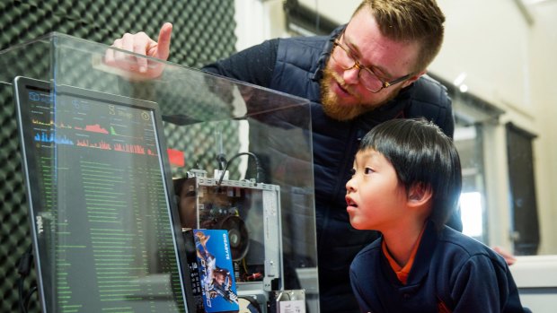 Eight-year-old Wooranna Park Primary School student Seth Yee and teacher Kieran Nolan with a server that authenticates Blockchain data. 