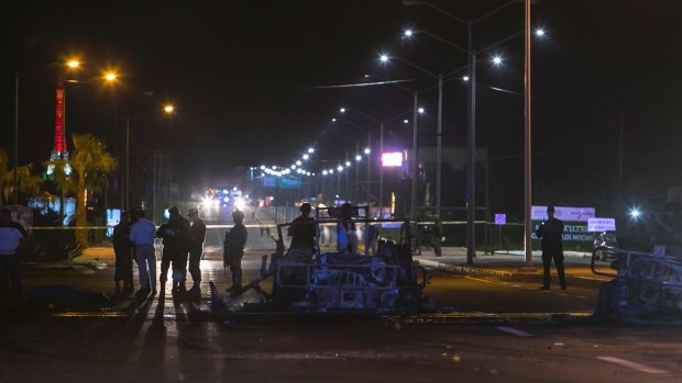 Investigators examine the site where a military convoy was ambushed using grenades and high-powered guns, killing five soldiers in the city of Culiacan, Mexico.