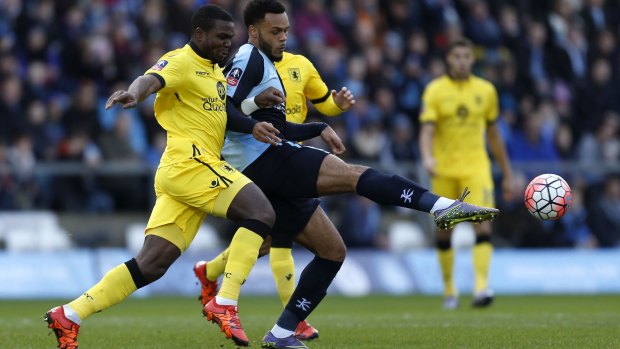 Wycombe Wanderers' Aaron Holloway and Aston Villa's Jores Okore battle for the ball.