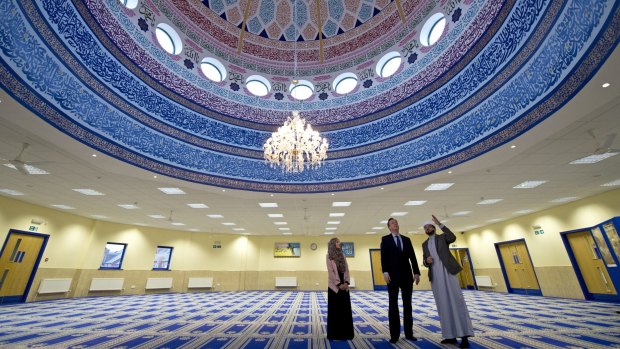 Prime Minister David Cameron talks with Imam Qari Asim (R) and Shabana Muneer, a member of Makkah Masjid mosque's women's group, as he visits Makkah Masjid Mosque in Leeds, England.