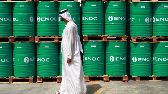 A visitor passes ENOC-branded oil barrels stored at the Emirates National Oil Co. 