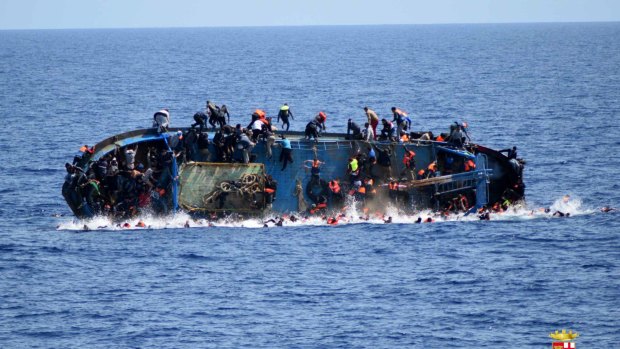 People jump out of a boat right before it overturns off the Libyan coast in 2016.
