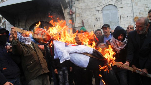 Palestinian protesters burn an effigy of US President Donald Trump.