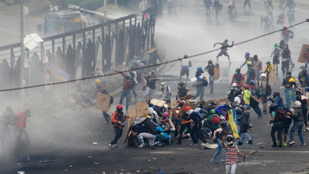Demonstrators clash with authorities on the fence of La Carlota Air Base in Caracas, Venezuela.