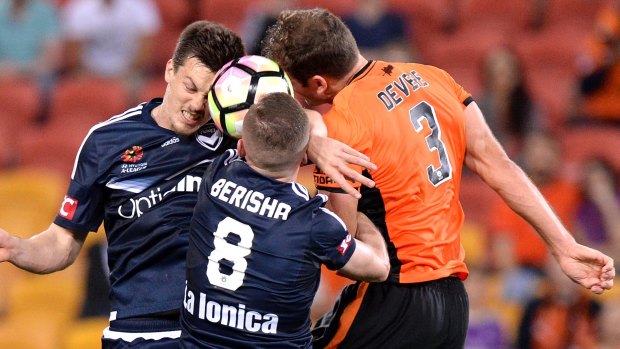 Heads up:  Luke DeVere of the Roar competes for the ball against Besart Berisha and James Donache of the Victory.