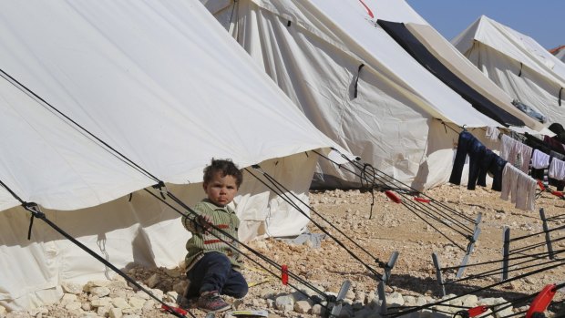 A child plays around a temporary refugee camp for displaced Syrians in northern Syria.