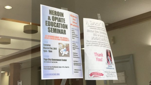 A flyer for a heroin and opiate education seminar hangs along side other community news at the front door of the Tipp City, Ohio municipal offices. 