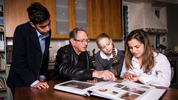 Holocaust survivor Peter Halas shows (L-R) Alex Tofler, Lily Shrire and Zoe Menczel Shrire a photo album of his family that were affected by the holocaust. 