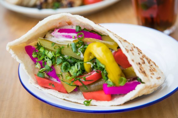 Pita filled with colourful pickles and falafel.