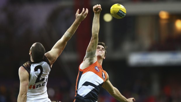  Phil Davis of the Giants punches the ball  against Hawthorn at Spotless Stadium.