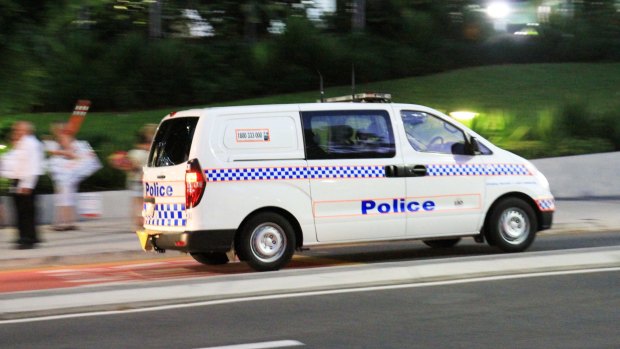 Police are investigating the armed robbery of two people at an intersection on the Gold Coast.
