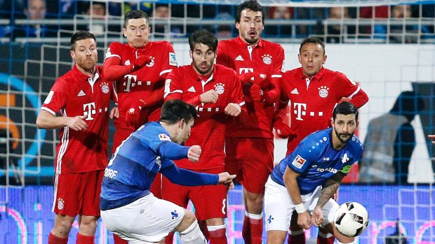 Long way between cellar and penthouse: Darmstadt's Jerome Gondorf takes rare aim at Bayern Munich's goal in a clash between the Bundesliga's also-rans and its glamour club.