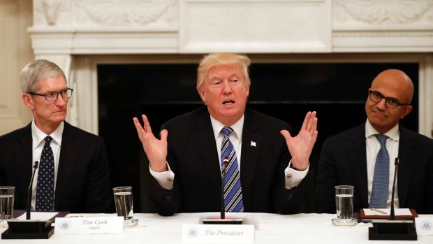 Donald Trump flanked by Apple chief executive Tim Cook (left) and Microsoft CEO Satya Nadella at the White House this week.