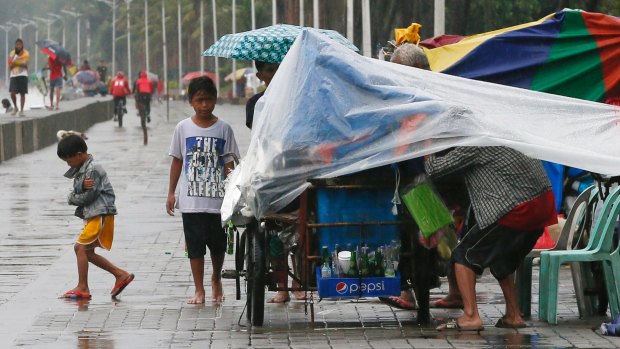 A market stall owner takes shelter on a promenade in Manila on Sunday.