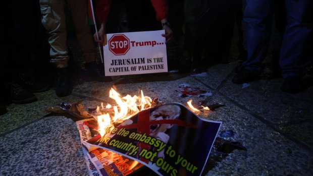 Palestinian burn a poster of the US President Donald Trump during a protest in Bethlehem, West Bank.