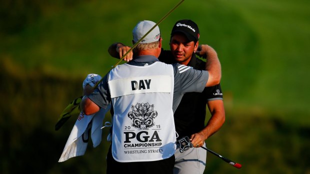 At last: Jason Day celebrates with his caddie Colin Swatton.